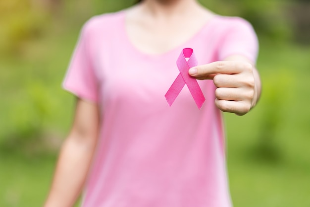 Mulher segurando fita rosa para apoiar pessoas que vivem e estão doentes