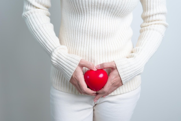 Mulher segurando forma de coração vermelho Gravidez Sistema reprodutivo menstruação e conceito de ginecologia