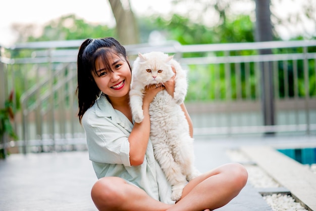 Mulher segurando gato brincando em casa com amor por gatos O sorriso brilha em seu vínculo com seu gato fofo de estimação A relação entre pessoas e gatos donos de gatos gatos domésticos gatos gordos