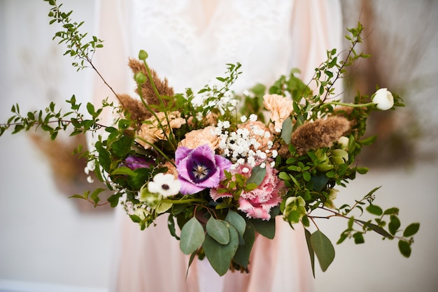 Mulher segurando o buquê de casamento elegante grande e bonito. Flores coloridas na decoração florística de casamento. Noiva manhã