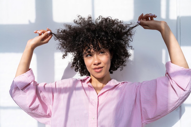 Foto mulher segurando o cabelo contra a parede branca