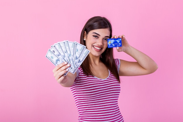 mulher segurando o cartão de crédito e fã de notas de dólar