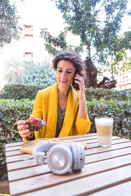 Foto mulher segurando o celular em um terraço ao ar livre