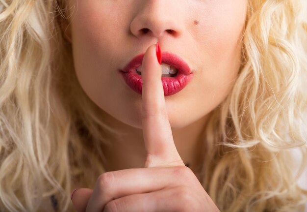 Foto mulher segurando o dedo pressionado contra os lábios