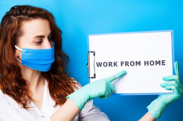 Mulher segurando o espaço em branco com inscrição trabalho em casa, chamando para parar de espalhar covid-19.