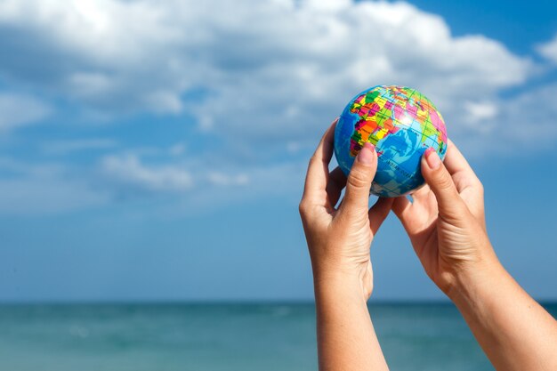 Mulher segurando o globo da terra em um fundo do mar.