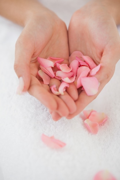 Foto mulher segurando pétalas de rosa rosa