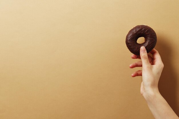 Mulher segurando rosquinha deliciosa na cor de fundo