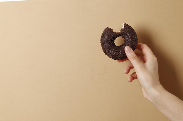 Mulher segurando rosquinha deliciosa na cor de fundo