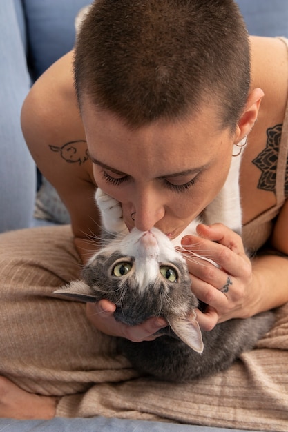 Mulher segurando seu adorável gatinho dentro de casa