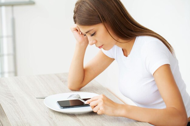 Mulher segurando smartphone, digitando mensagem, conversando com amigos nas redes sociais.