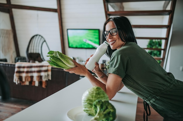 Foto mulher segurando smartphone e laptop na mesa