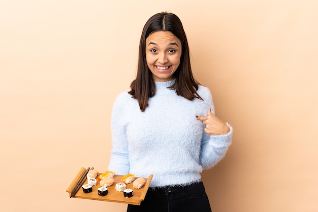 Mulher segurando sushi em estúdio