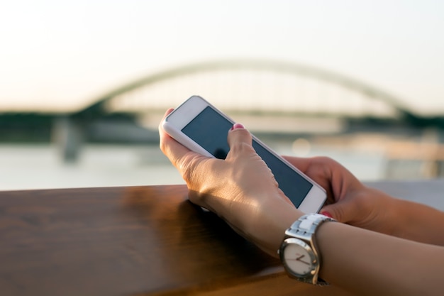 Mulher segurando telefone inteligente nas mãos