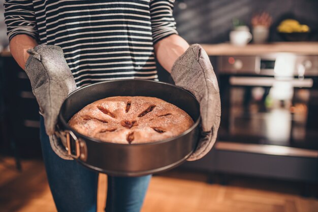 Mulher segurando torta de maçã recém-assados