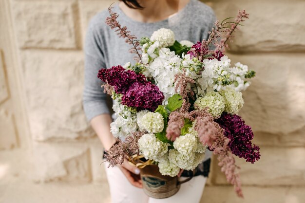 Mulher segurando um buquê de flores sazonais