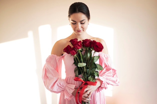 Mulher segurando um buquê de lindas rosas vermelhas para o dia dos namorados