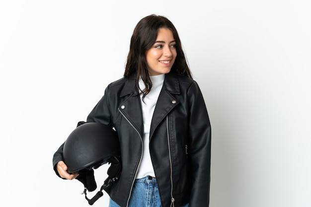 Mulher segurando um capacete de motocicleta em branco, olhando para o lado e sorrindo