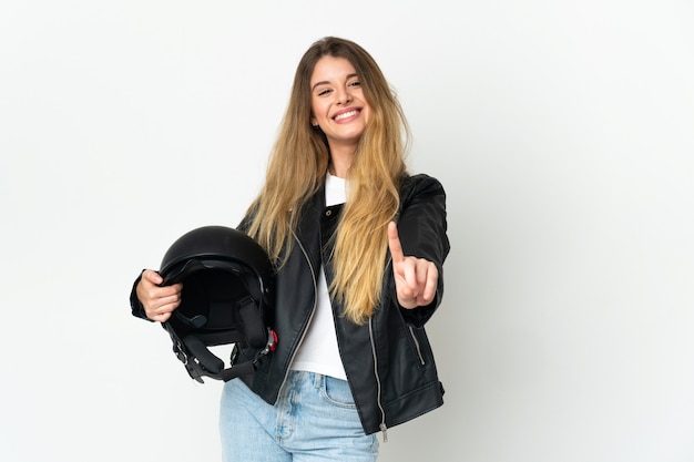 Mulher segurando um capacete de motociclista isolado no fundo branco, mostrando e levantando um dedo