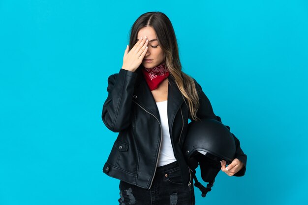 Mulher segurando um capacete de motociclista posando isolado contra a parede em branco