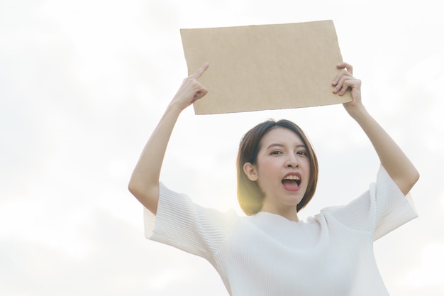 Mulher segurando um cartaz da caixa em um protesto