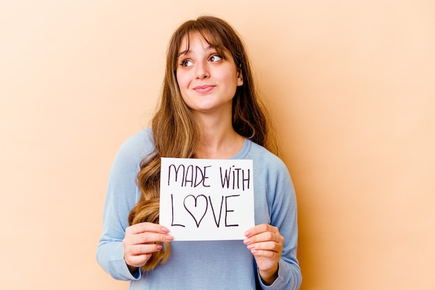 Mulher segurando um cartaz feito com amor