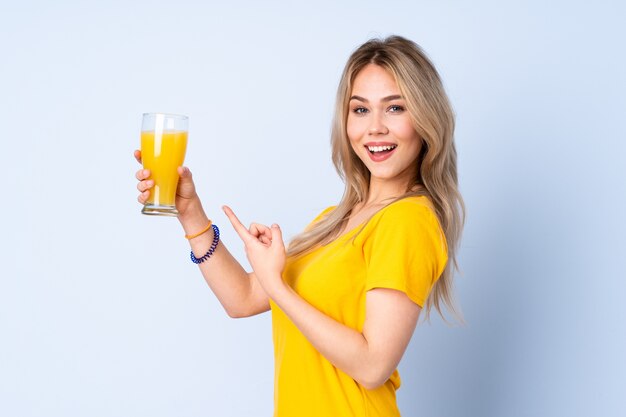 Mulher segurando um copo de suco de laranja