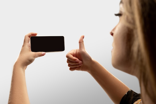 Mulher segurando um gadget em um fundo branco