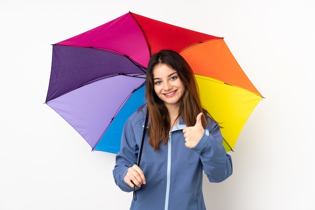 Mulher segurando um guarda-chuva na parede branca, dando um polegar para cima gesto