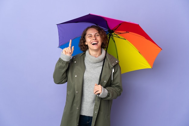 mulher segurando um guarda-chuva posando isolada contra a parede em branco