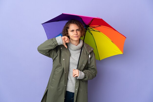 mulher segurando um guarda-chuva posando isolada contra a parede em branco