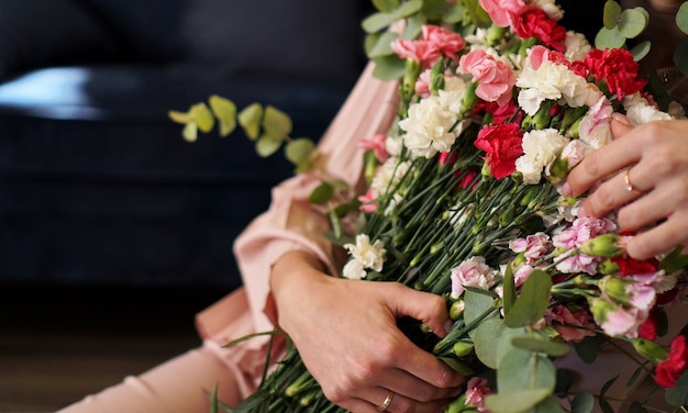 Mulher segurando um lindo buquê de flores desabrochando com rosas frescas de areia movediça