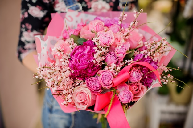 Mulher segurando um lindo buquê de flores em tons de rosa