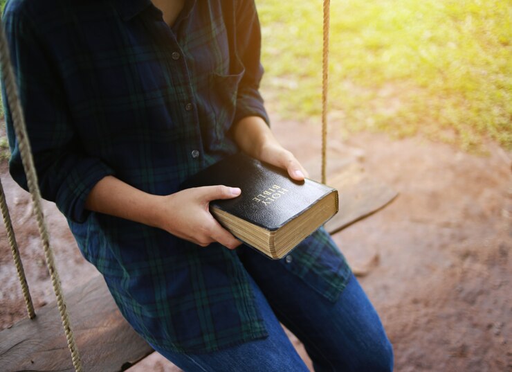 Foto mulher segurando um livro, a bíblia, a natureza.