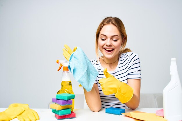 Mulher segurando um pano detergente de limpeza fornece trabalho doméstico interior Foto de alta qualidade