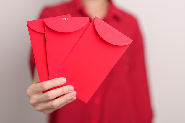 Mulher segurando um presente de dinheiro de envelope vermelho chinês para feliz feriado do Ano Novo Lunar