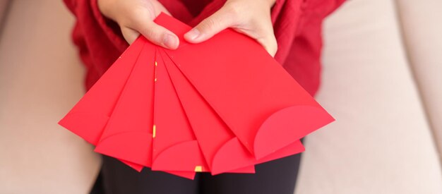 Mulher segurando um presente de dinheiro de envelope vermelho chinês para feliz feriado do Ano Novo Lunar