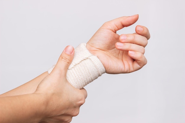Foto mulher segurando um pulso enfaixado na mão lesões no pulso dor no braço síndrome do túnel do carpo