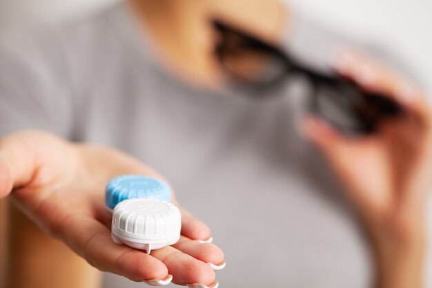 Mulher segurando um recipiente com lentes de contato