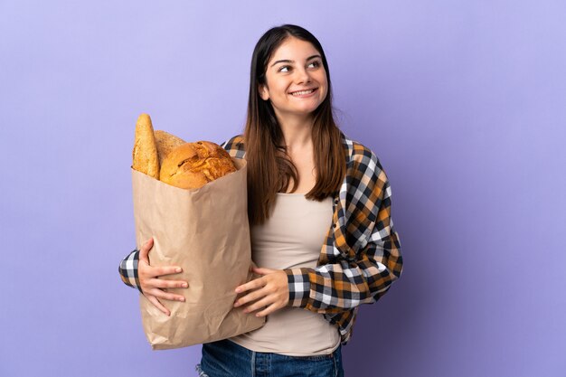 Mulher segurando um saco cheio de pão