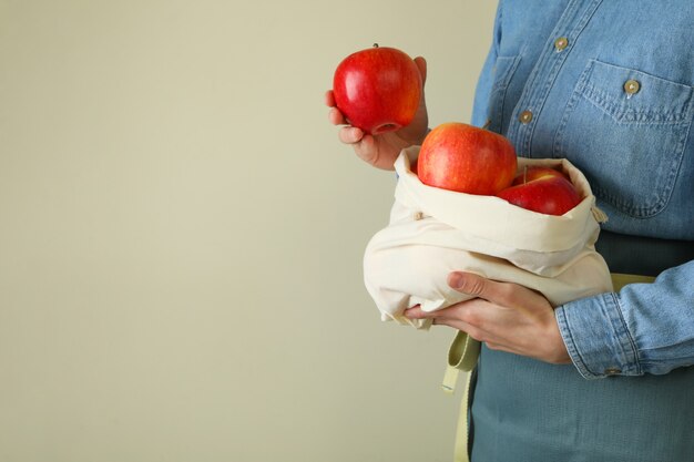 Foto mulher segurando um saco com maçãs vermelhas maduras