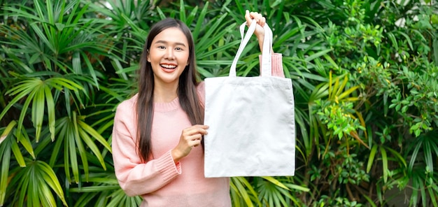 Mulher segurando um saco de algodão eco em branco conceito de design de ambiente mockup