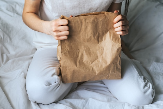 Mulher segurando um saco de papel ecológico com comida nas mãos