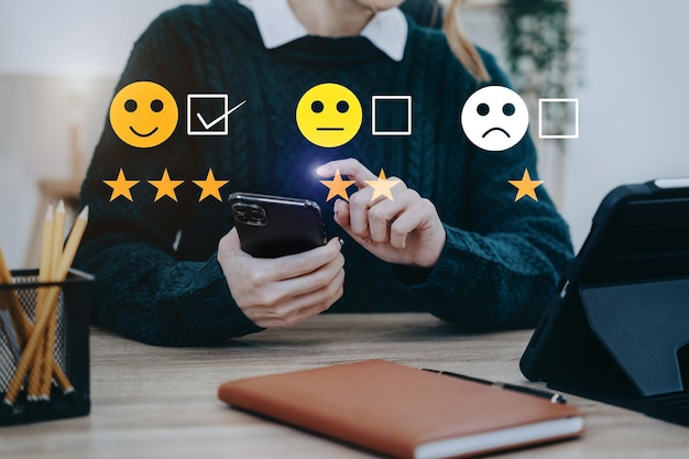 Mulher segurando um smartphone digital com caixas de seleção carinhas sorridentes excelente para pesquisa de satisfação conceito de experiência do cliente feliz