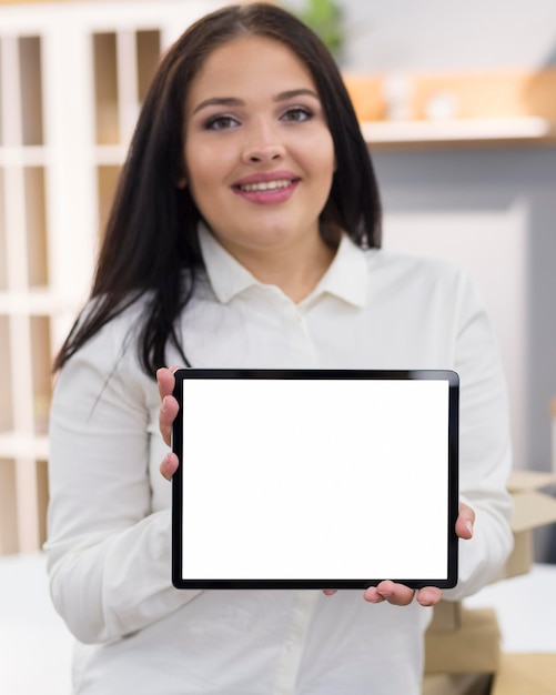 Foto mulher segurando um tablet de tela vazia