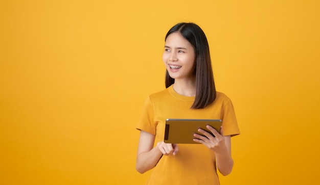 Mulher segurando um tablet digital e olhando para a direita