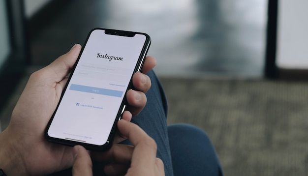 Mulher segurando um telefone com login do aplicativo Instagram na tela