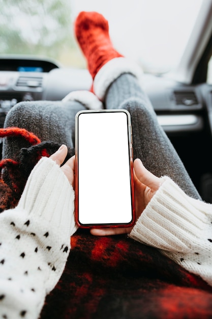 Foto mulher segurando um telefone vazio no carro