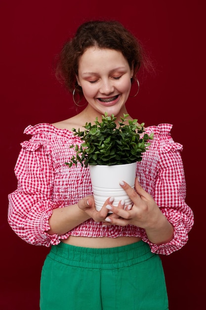 Mulher segurando um vaso de flores nas mãos posando inalterado