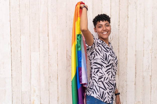 Mulher segurando uma bandeira do orgulho gay em apoio ao Orgulho Gay na rua
